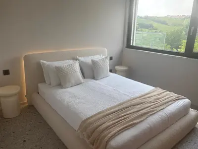 a white bed with white pillows and a window at Vila Solini in Kozana