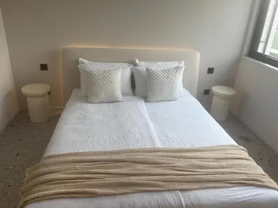 a bedroom with a bed with white sheets and pillows at Vila Solini in Kozana