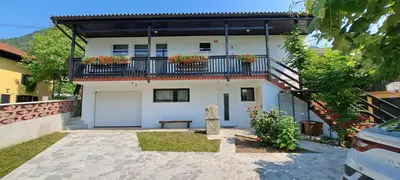 a house with a balcony with flowers on it at Biba House in Tolmin