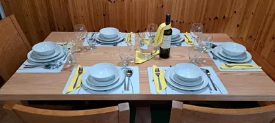 a wooden table with white plates and silverware on it at Biba House in Tolmin