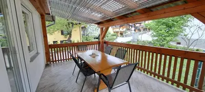a wooden balcony with a table and chairs on it at Biba House in Tolmin