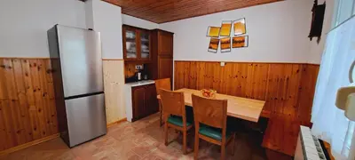 a kitchen with a wooden table and a refrigerator at Biba House in Tolmin