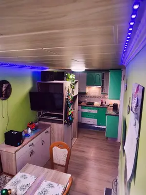 a small kitchen with green cabinets and a table at La Vita House Camp Terme 3000 Moravske Toplice 2 Thermal Tickets Included Free Bikes in Moravske Toplice
