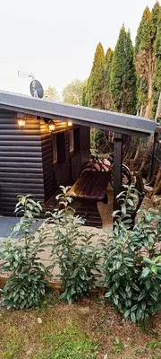 a patio with a table and a bench under a roof at La Vita House Camp Terme 3000 Moravske Toplice 2 Thermal Tickets Included Free Bikes in Moravske Toplice