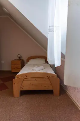 a wooden bed in a room with a window at Martinov Hram in Bovec