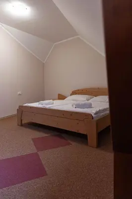 a bedroom with a wooden bed in a room at Martinov Hram in Bovec