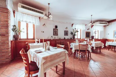 a dining room with white tables and chairs and windows at Martinov Hram in Bovec