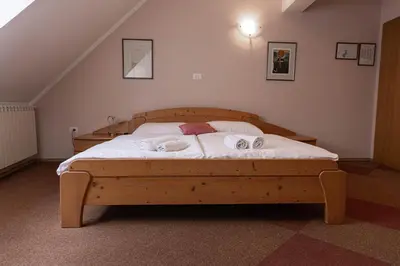 a bedroom with a wooden bed with two towels on it at Martinov Hram in Bovec