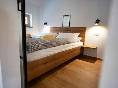 a bedroom with a bed with a wooden headboard at Pr Štepiherju in Luče