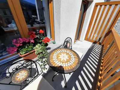 a table and chairs on a balcony with flowers at Apartments Hlapi with SPA in Kobarid