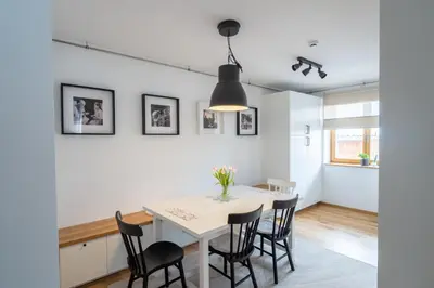 a white dining room with a white table and black chairs at Apartment ALPINE IBEX, Nordic House, Kranjska Gora - Center in Kranjska Gora