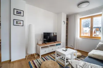 a living room with a couch and a tv at Apartment ALPINE IBEX, Nordic House, Kranjska Gora - Center in Kranjska Gora