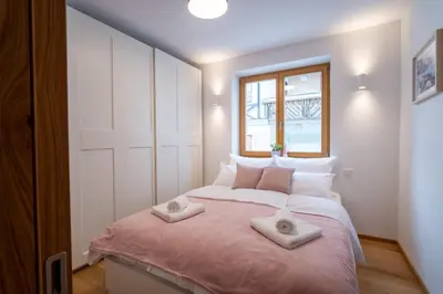 a bedroom with a large bed with two towels on it at Apartment ALPINE IBEX, Nordic House, Kranjska Gora - Center in Kranjska Gora