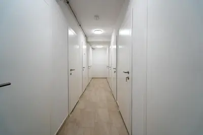 a hallway with white doors and a wooden floor at Apartment ALPINE IBEX, Nordic House, Kranjska Gora - Center in Kranjska Gora