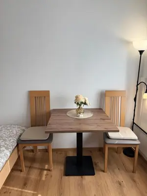 a dining room table with a vase of flowers on it at AlpNest with free parking in Bovec