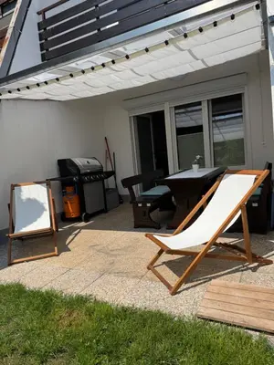 a patio with a chair and a table and a grill at AlpNest with free parking in Bovec