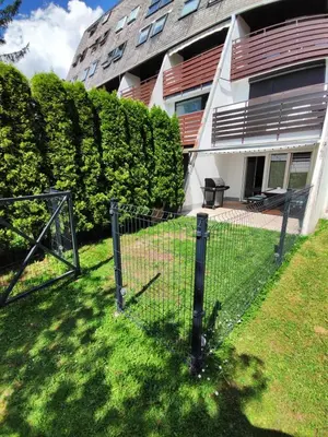 a fence in the grass in front of a building at AlpNest with free parking in Bovec