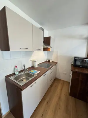 a kitchen with white cabinets and a sink in it at AlpNest with free parking in Bovec