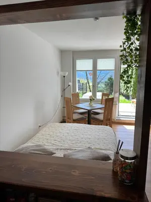 a bedroom with a bed and a table and chairs at AlpNest with free parking in Bovec