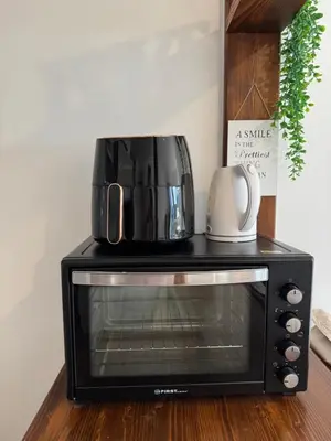 a black toaster oven with a coffee pot on top at AlpNest with free parking in Bovec