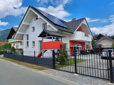 a white house with a black fence at Comfortable 4 room 4 full Family in Tržič