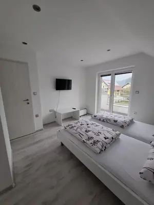 a white room with two beds and a television at Comfortable 4 room 4 full Family in Tržič