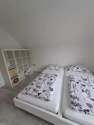 two beds in a room with white walls at Comfortable 4 room 4 full Family in Tržič