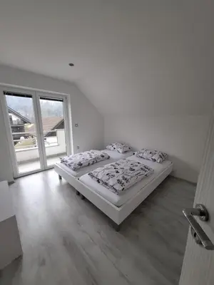 a bedroom with two beds and a large window at Comfortable 4 room 4 full Family in Tržič