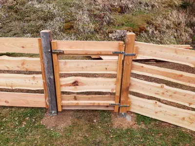 a wooden fence in the grass next to a field at Glamping apartma Oaza miru in Preddvor