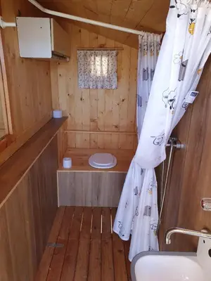 a bathroom with a toilet and a shower curtain at Glamping apartma Oaza miru in Preddvor