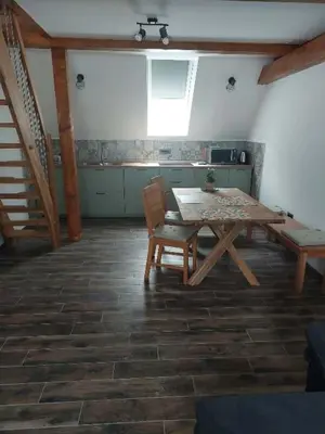a table and chair in a room with a kitchen at APARTMAJI VITEZ Apartma 4 in Bovec
