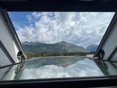 a view of a glass window with mountains in the background at APARTMAJI VITEZ Apartma 4 in Bovec