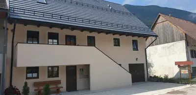 a white building with a large white sign in front of it at APARTMAJI VITEZ Apartma 4 in Bovec