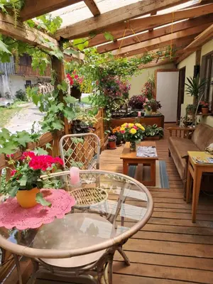 a patio with a table and chairs and flowers at Art & Sun in Kočevje