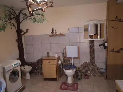a bathroom with a tree and a toilet and a sink at Art & Sun in Kočevje