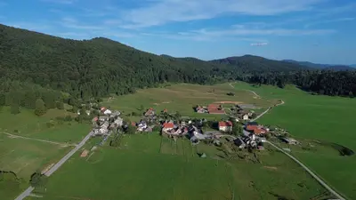 an aerial view of a village in a green field at Art & Sun in Kočevje