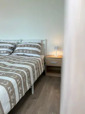 a bedroom with a bed and a night stand with a lamp at Apartments Linden Tree in Kamnik