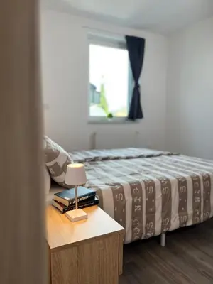 a bedroom with a bed and a table with a lamp at Apartments Linden Tree in Kamnik