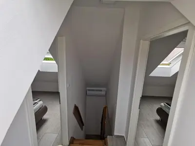 an attic room with a staircase and a window at Apartma Zala in Brežice