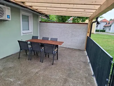 a wooden table and chairs on a patio at Apartma Zala in Brežice