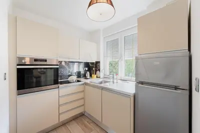 a kitchen with white cabinets and a refrigerator at Apartma BAZA in Bovec