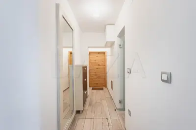 a hallway with white walls and wooden flooring in a house at Apartma BAZA in Bovec