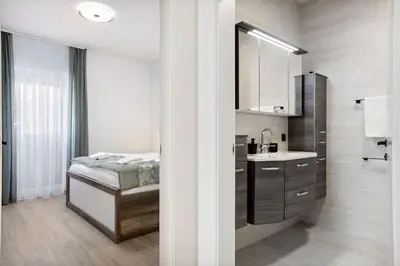 a bathroom with a bed and a sink at Kristal Lux Aparments with a balcony in Rogaška Slatina