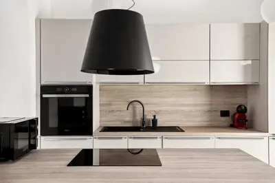 a kitchen with white cabinets and a black sink at Kristal Lux Aparments with a balcony in Rogaška Slatina