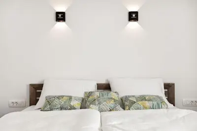 a bedroom with white walls and two beds with pillows at Kristal Lux Aparments with a balcony in Rogaška Slatina