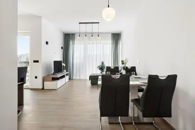 a dining room and living room with a table and chairs at Kristal Lux Aparments with a balcony in Rogaška Slatina