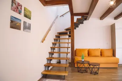 a living room with a couch and a staircase at Zelena harmonija in Moravske Toplice