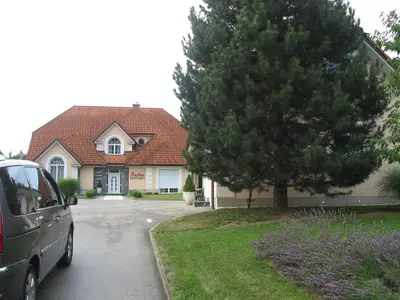 a car parked in front of a house with a tree at Apartmaji in sobe RaMar in Straža