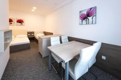 a room with a table and chairs and a bed at Apartmaji in sobe RaMar in Straža