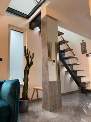 a living room with a staircase and a cactus at SISSI Apartment Banovci in Veržej